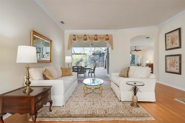 living room featuring hardwood / wood-style flooring, ceiling fan, and ornamental molding