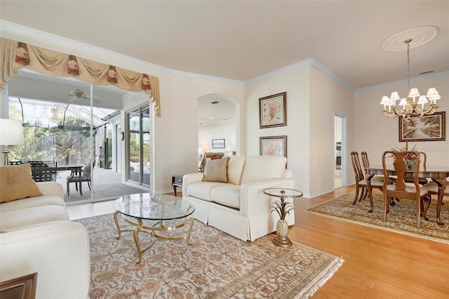 living room with hardwood / wood-style floors, a notable chandelier, and crown molding