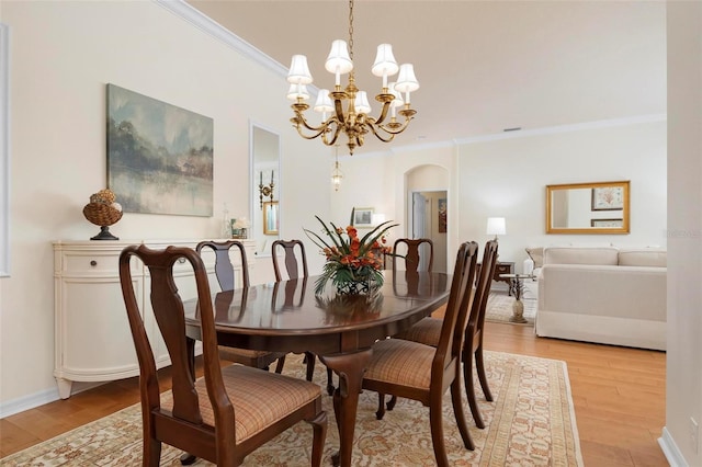 dining room featuring a chandelier, crown molding, and light hardwood / wood-style floors