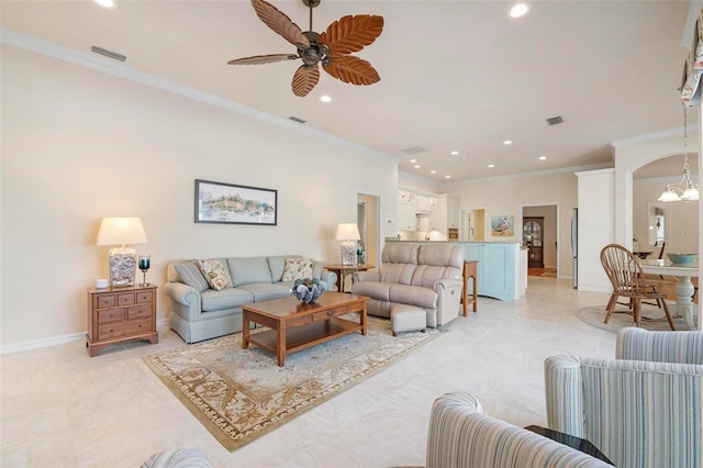 living room with ceiling fan with notable chandelier and ornamental molding