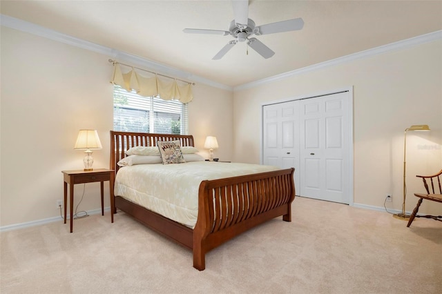 carpeted bedroom with a closet, ceiling fan, and ornamental molding