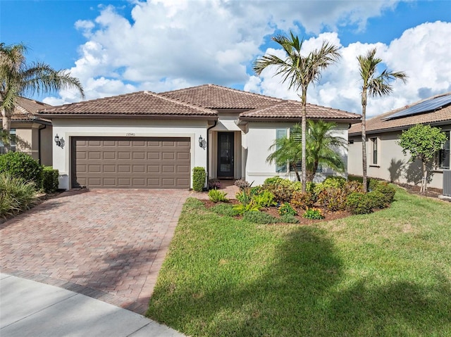 mediterranean / spanish house featuring a garage and a front lawn