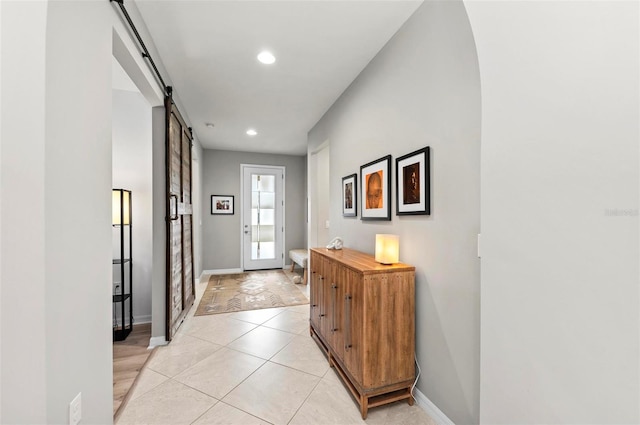 doorway to outside featuring light tile patterned floors and a barn door