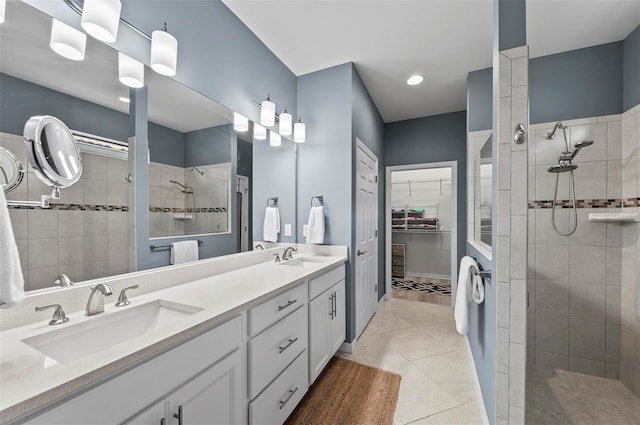 bathroom featuring a tile shower, vanity, and tile patterned floors