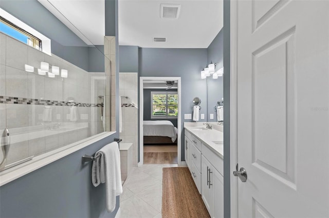 bathroom featuring hardwood / wood-style flooring, vanity, and tiled shower