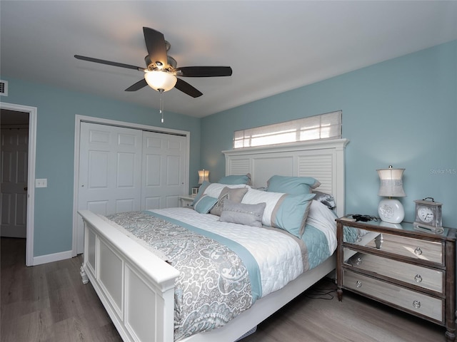 bedroom with dark hardwood / wood-style flooring, a closet, and ceiling fan