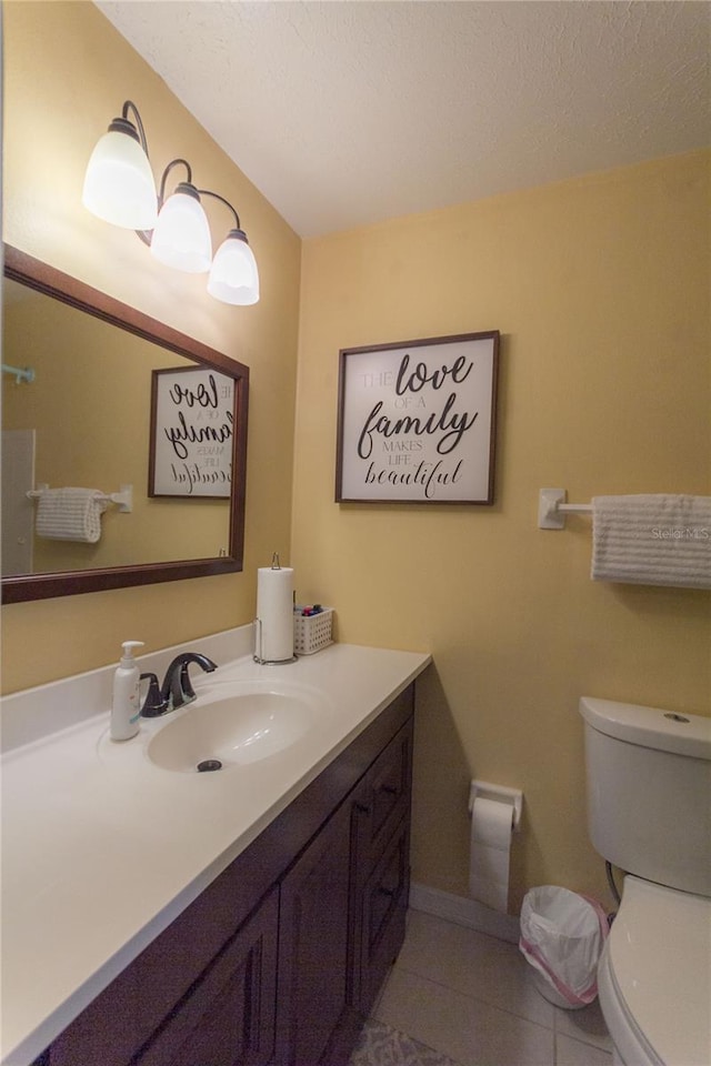 bathroom featuring tile patterned flooring, a textured ceiling, vanity, and toilet