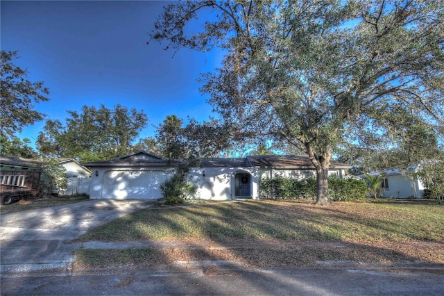 ranch-style home featuring a garage and a front lawn