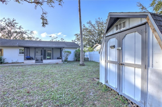 exterior space featuring a yard, a shed, and a sunroom