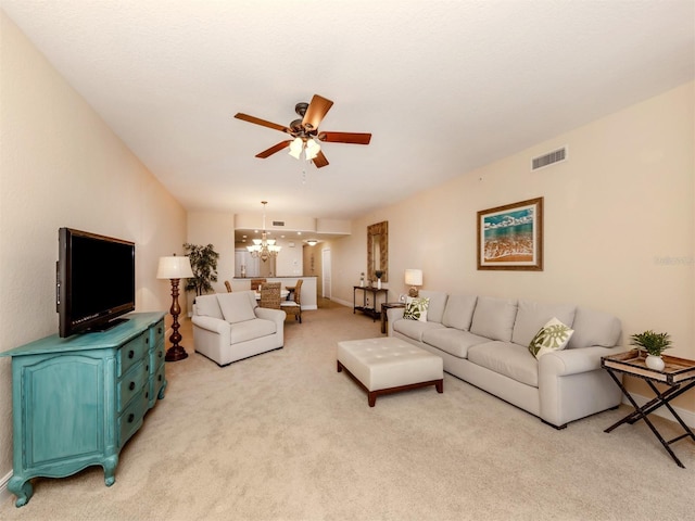 living room with ceiling fan with notable chandelier and light colored carpet