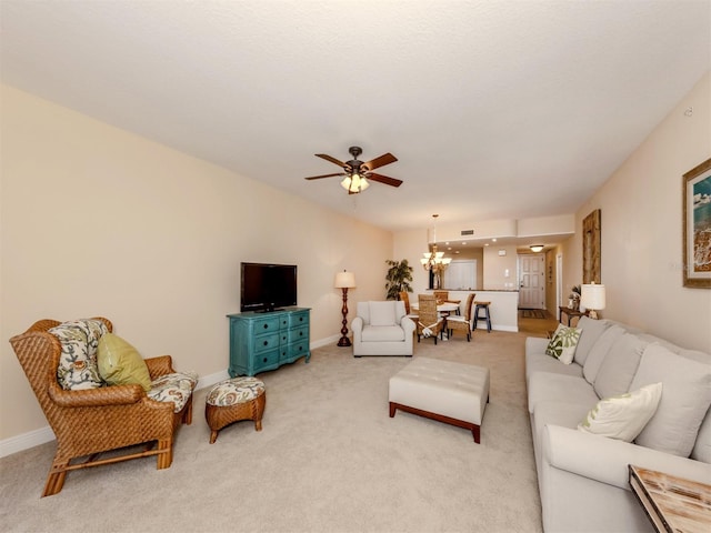 living room with light colored carpet and ceiling fan with notable chandelier