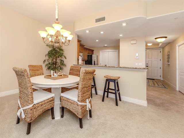 dining space featuring light colored carpet and an inviting chandelier