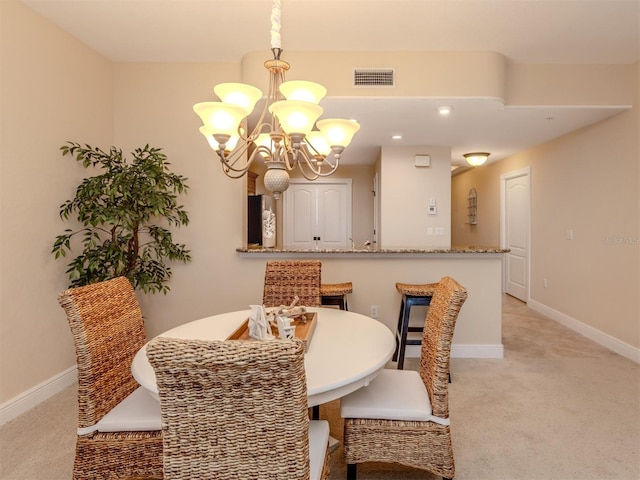 carpeted dining space with a chandelier