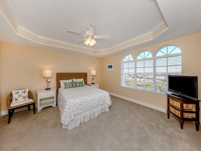 bedroom with ceiling fan, a raised ceiling, ornamental molding, and light carpet