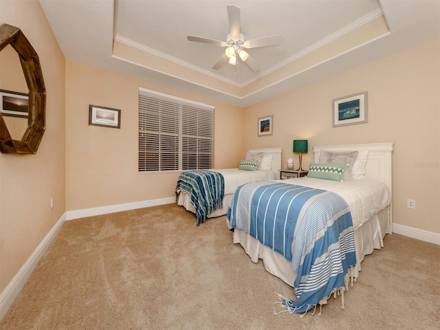 carpeted bedroom featuring a tray ceiling, ceiling fan, and ornamental molding