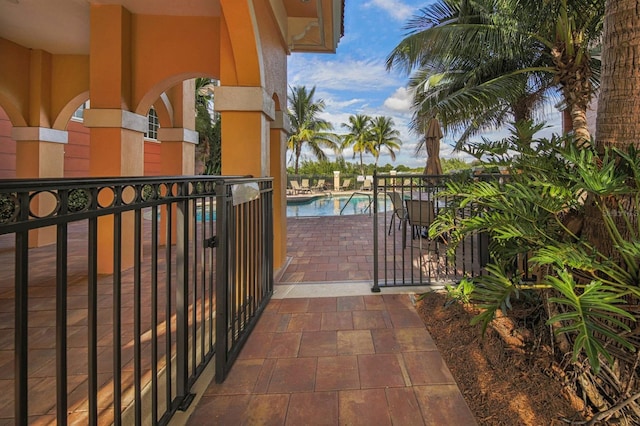 view of gate with a patio area and a community pool