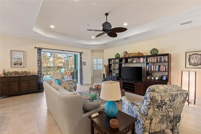 tiled living room featuring a tray ceiling, ceiling fan, and crown molding