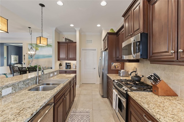 kitchen featuring sink, a chandelier, pendant lighting, light tile patterned floors, and appliances with stainless steel finishes