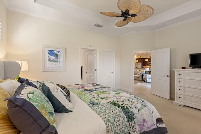 bedroom featuring ceiling fan, light carpet, and a tray ceiling