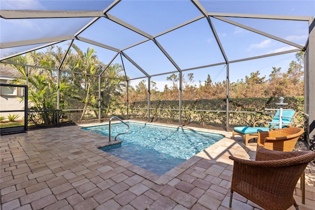 view of pool with glass enclosure and a patio area