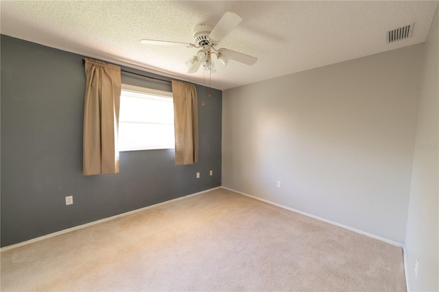 carpeted spare room with a textured ceiling and ceiling fan