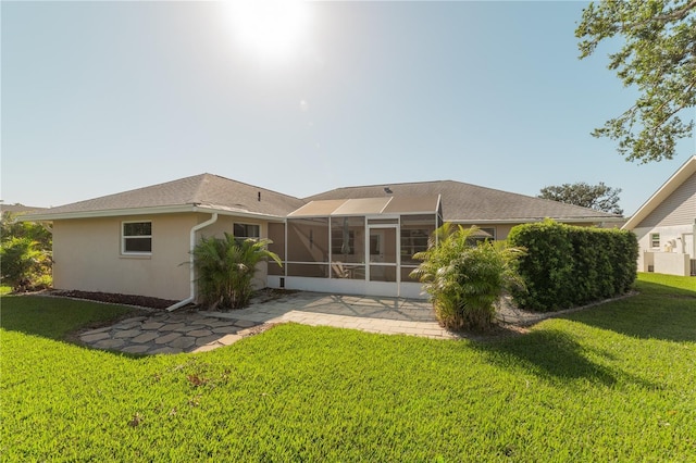 rear view of property with a yard, a patio area, and a lanai