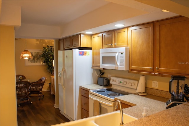 kitchen with pendant lighting, dark hardwood / wood-style floors, and white appliances