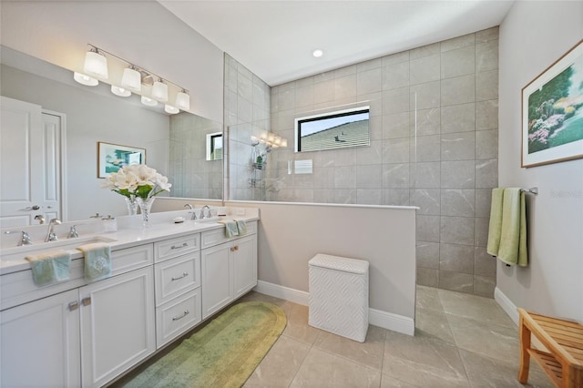 bathroom featuring double vanity, a sink, a walk in shower, tile patterned flooring, and baseboards