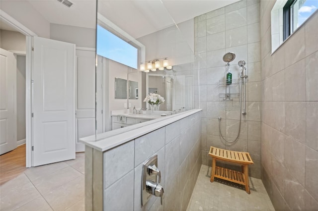 full bath featuring tile patterned flooring, walk in shower, and vanity