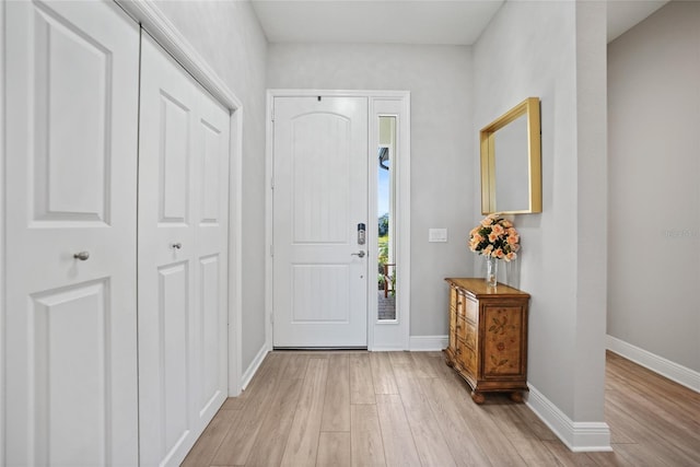 foyer entrance featuring light wood-style floors and baseboards