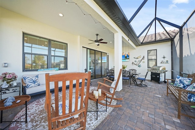 view of patio / terrace with glass enclosure, an outdoor living space, a ceiling fan, and area for grilling