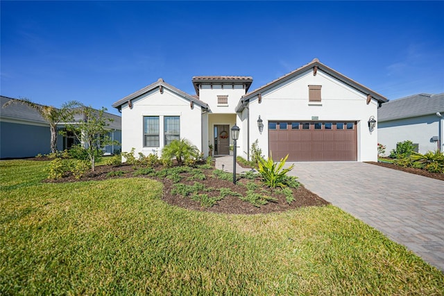 view of front of home featuring a front lawn, decorative driveway, an attached garage, and stucco siding