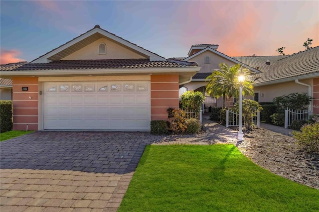 view of front of home featuring a garage and a lawn