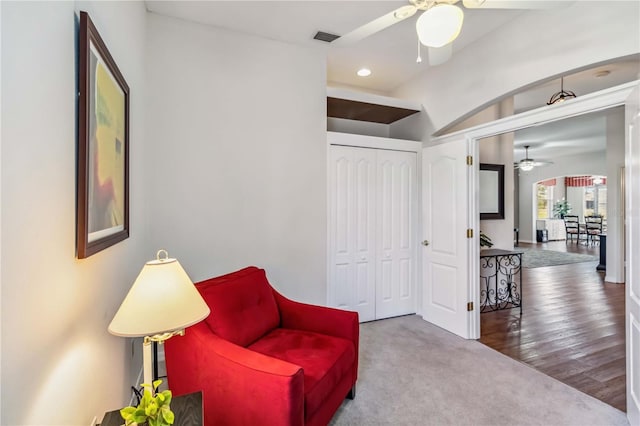 sitting room with ceiling fan and carpet