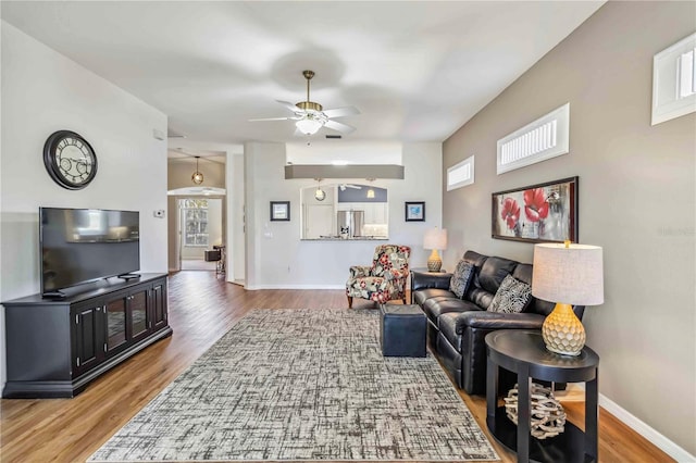 living room with wood-type flooring and ceiling fan