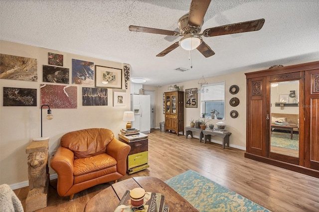 2191 Park Rd, Venice, FL 34293 - living room featuring a ceiling fan, light wood finished floors, a textured ceiling, baseboards, and visible vents