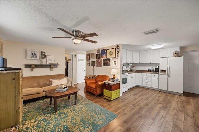 2191 Park Rd, Venice, FL 34293 - living area featuring a textured ceiling, visible vents, wood finished floors, and a ceiling fan