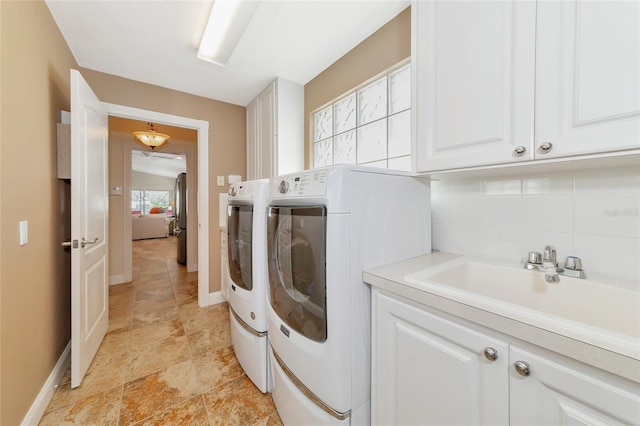 laundry room featuring separate washer and dryer, a wealth of natural light, sink, and cabinets