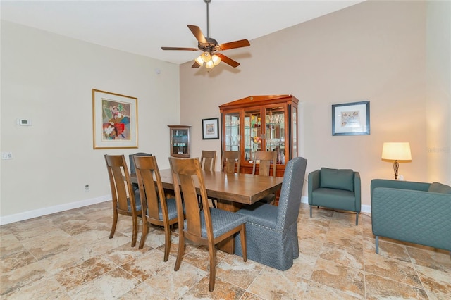 dining room featuring ceiling fan and a high ceiling