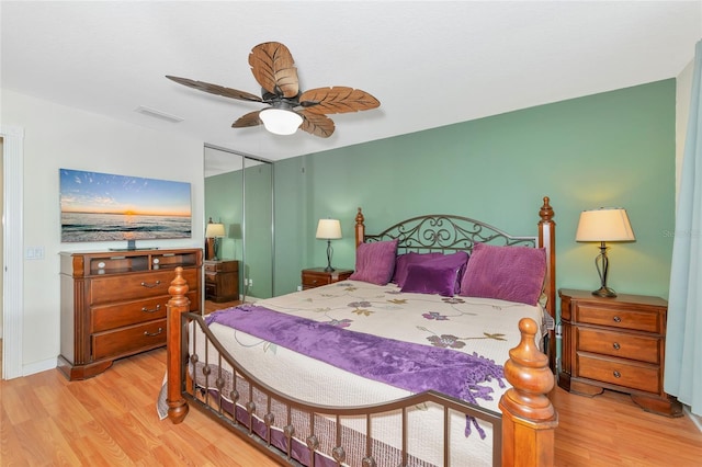 bedroom with ceiling fan, light wood-type flooring, and a closet