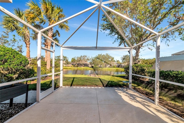 view of patio with a water view and glass enclosure