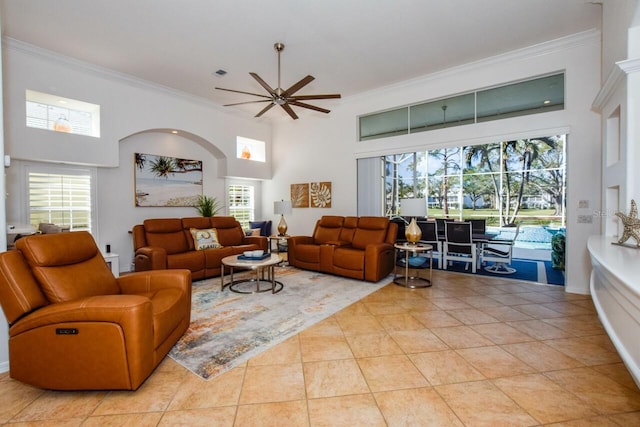 living room featuring ceiling fan, a healthy amount of sunlight, ornamental molding, and light tile patterned floors