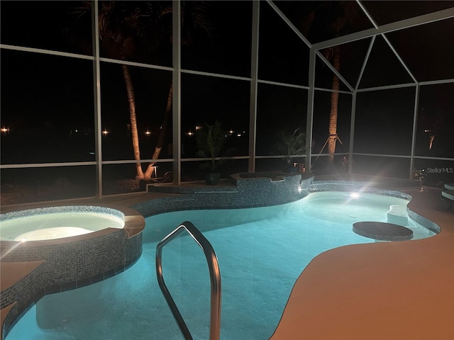 pool at night featuring an in ground hot tub