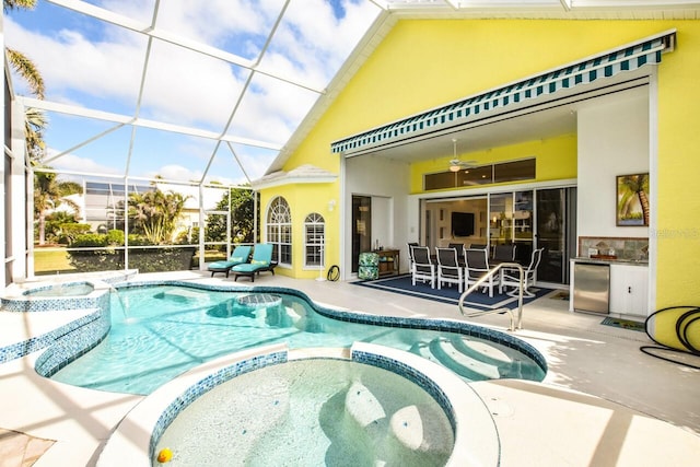 view of pool featuring a lanai, a patio, ceiling fan, and an in ground hot tub