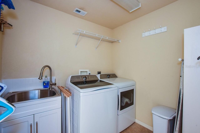 laundry room featuring cabinets, separate washer and dryer, and sink