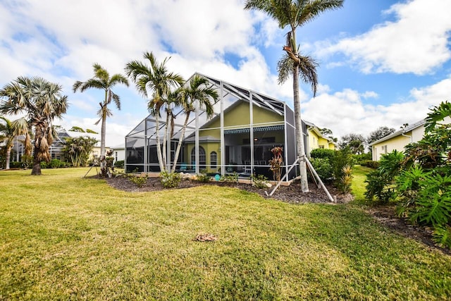 rear view of property with a yard and a lanai