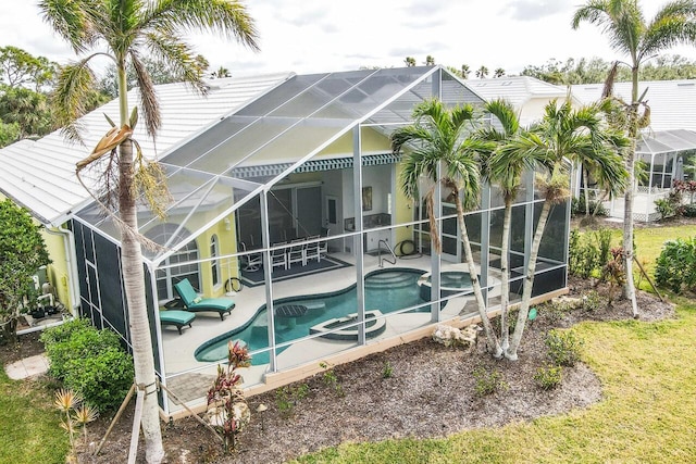 back of house with a pool with hot tub, a patio area, and glass enclosure