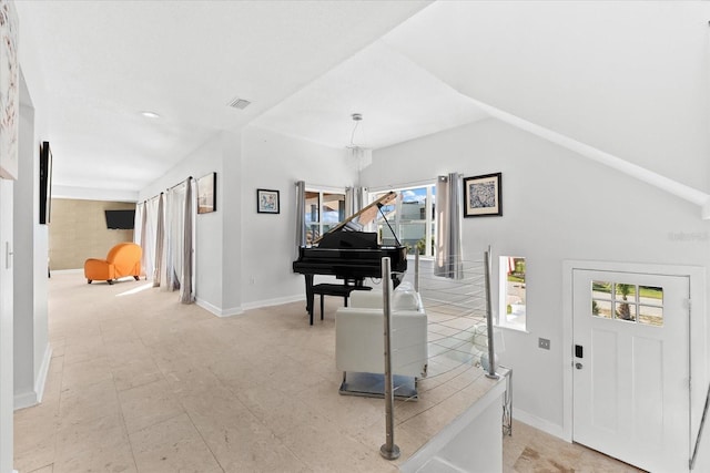 foyer entrance with plenty of natural light, a chandelier, and lofted ceiling