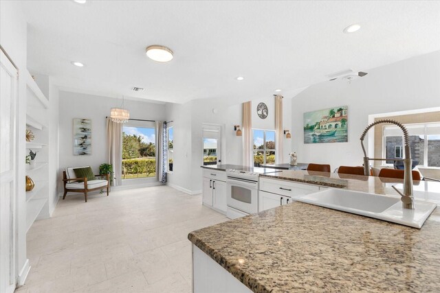 kitchen featuring white cabinets, electric range, a wealth of natural light, and sink