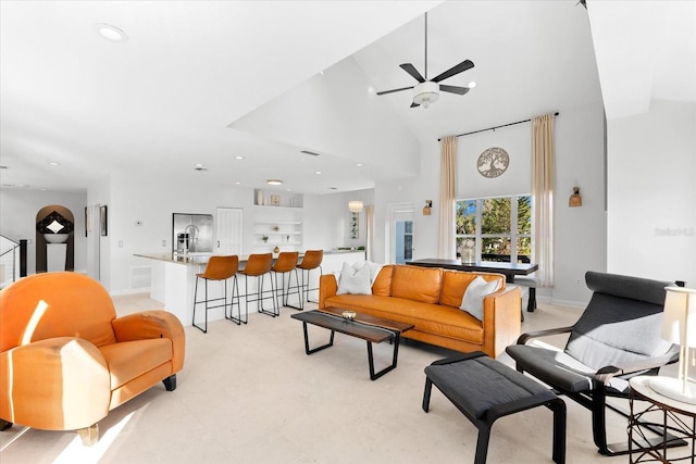 living room with ceiling fan, sink, and high vaulted ceiling